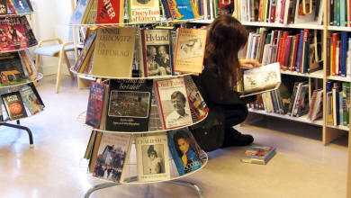 Barn läser böcker i ett bibliotek