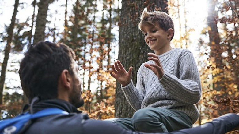 En man och en pojke sitter i skogen