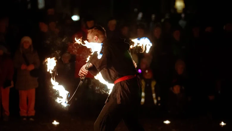 En man håller en eldstav framför en folkmassa