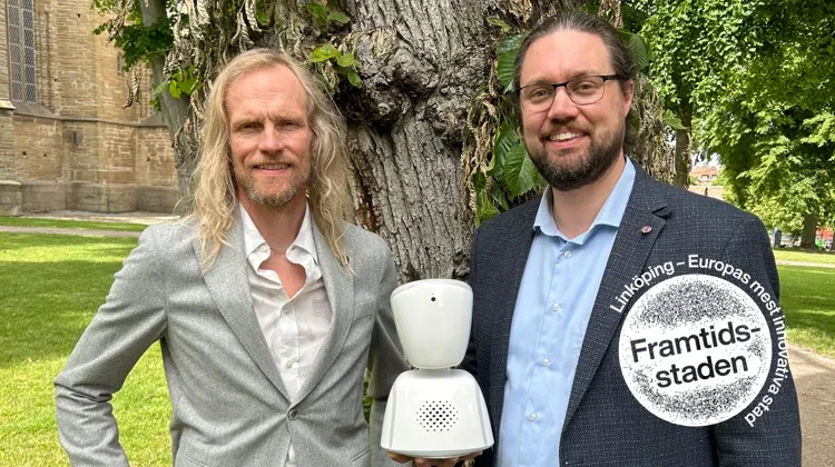 Patrik Landström och Erik Helmersson med en av de robotar som bidragit till att elever kunnat ta sig tillbaka till klassrummet från en tillvaro i ensamhet.