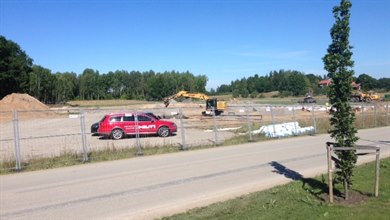Byggarbetsplats för den nya förskolan i Norrberga i Sturefors, med arbetsbil och grävmaskin parkerade på den schaktade marken